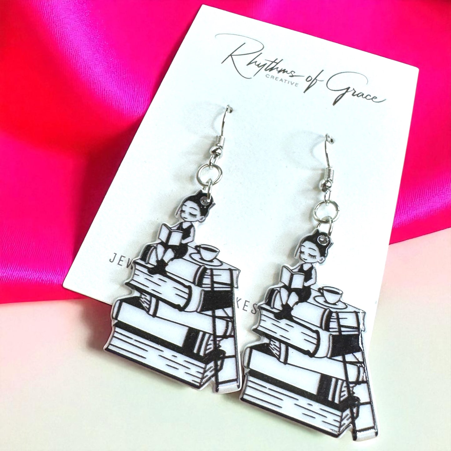 Pair of earrings on a 'Rhythms of Grace' card with a colorful background