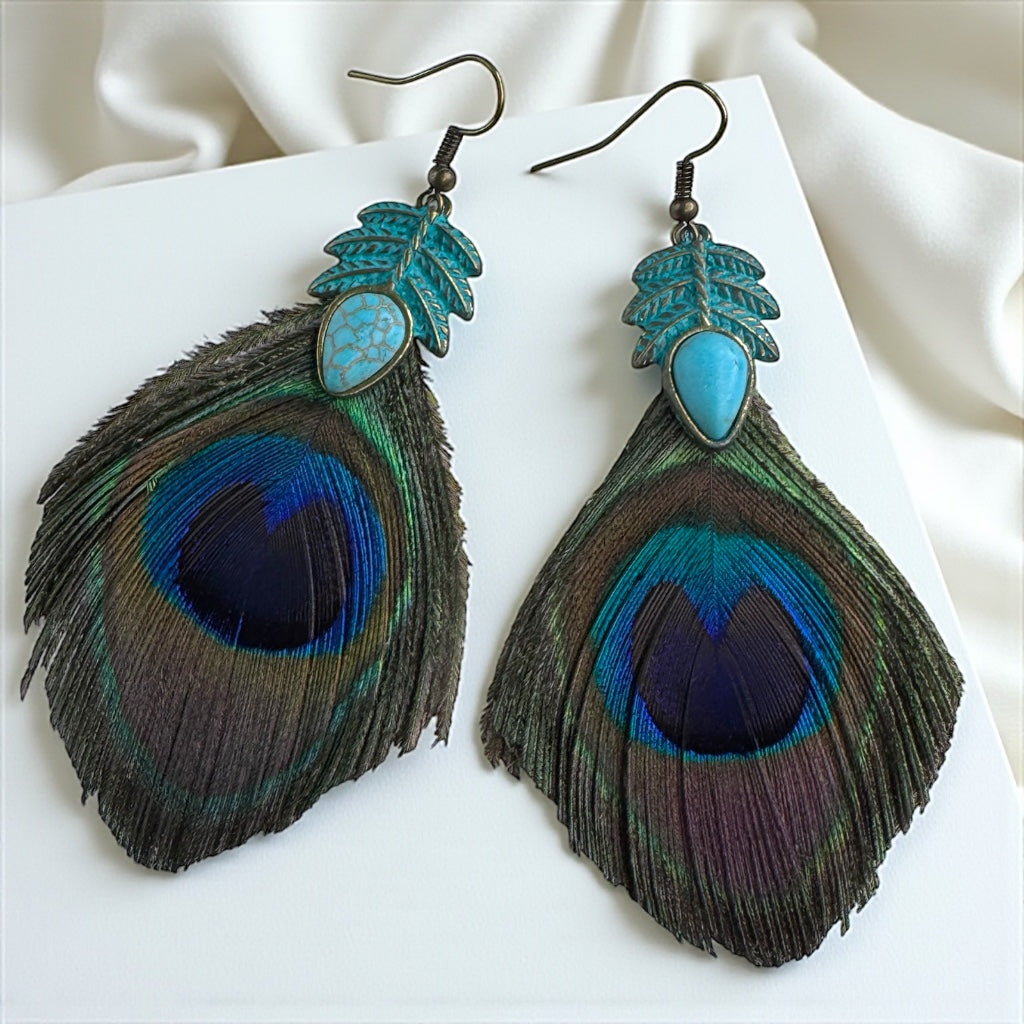 Peacock feather earrings with turquoise accents on a white background