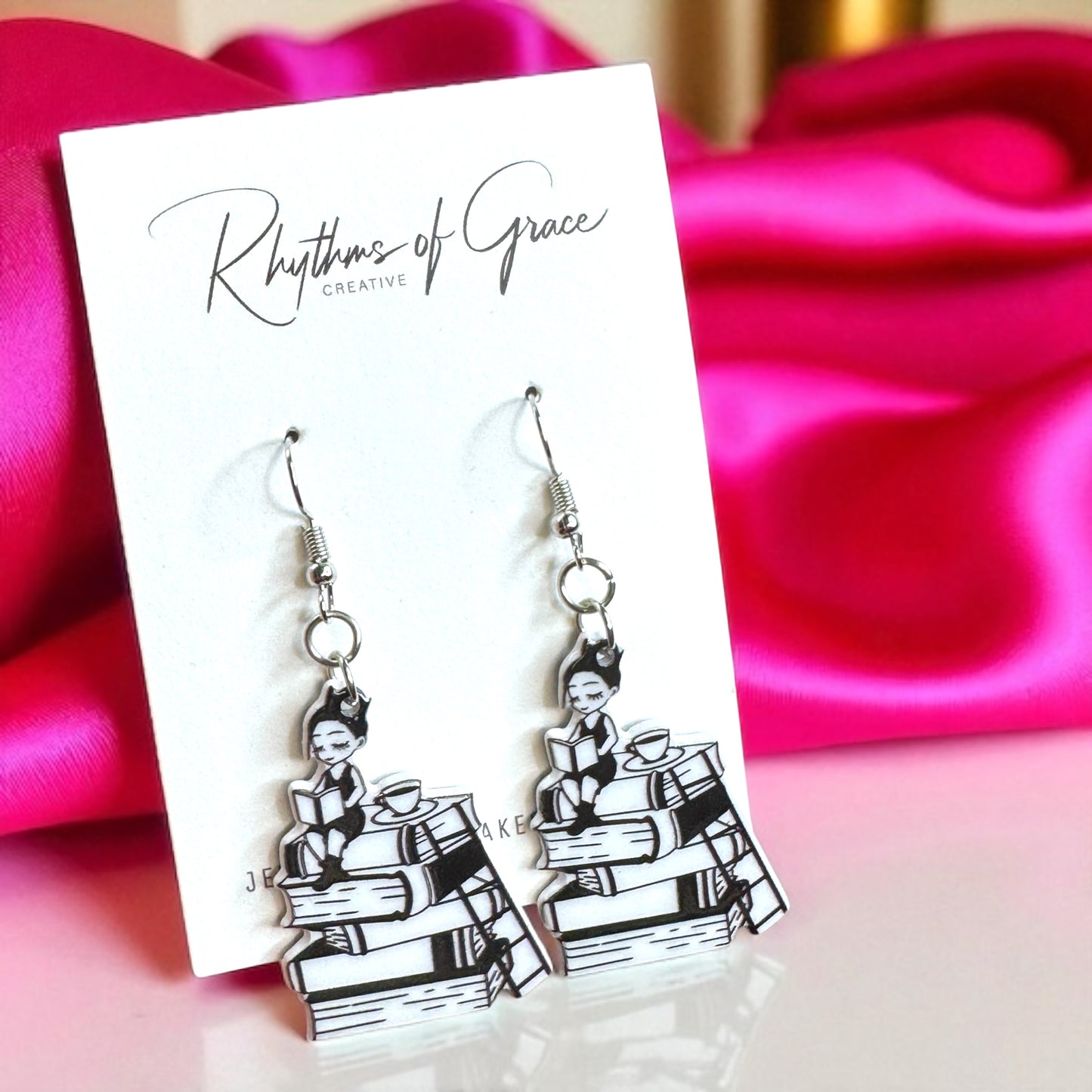 Black and white earrings on a 'Rhythms of Grace' card with pink fabric background