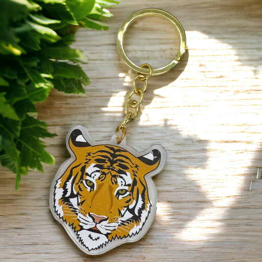 A vibrant acrylic keychain depicting a tiger's face in a gold-colored keyring.