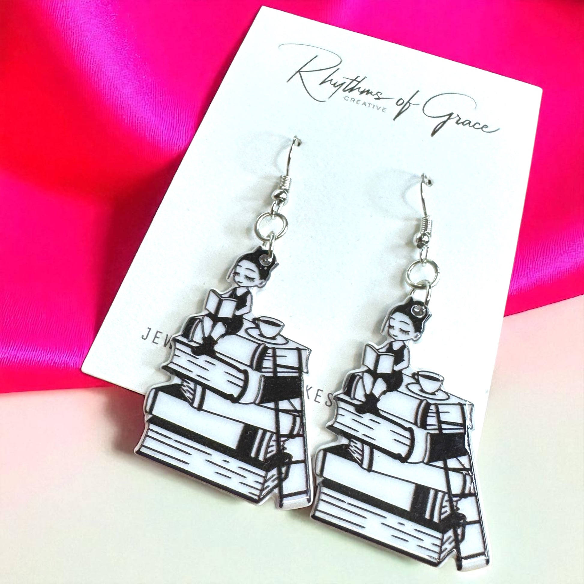 Pair of earrings on a 'Rhythms of Grace' card with a colorful background