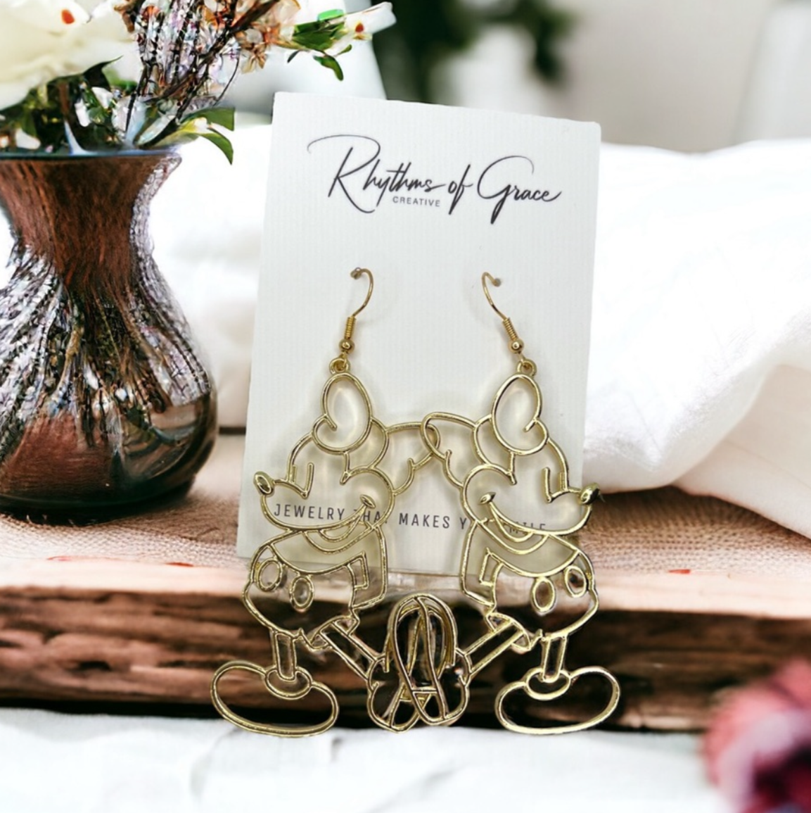 Gold earrings on a card with a blurred background