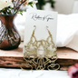 Gold earrings on a card with a blurred background