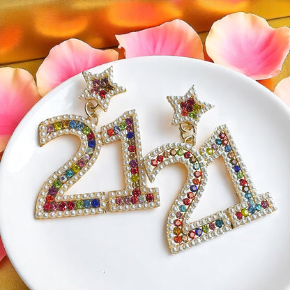 Sparkle into 21 with Our Rhinestone “21” Dangle Earrings!
