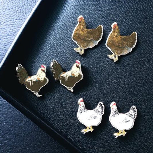 Set of chicken-shaped pins on a dark blue surface