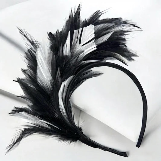 A black and white feathered headband on a white surface.